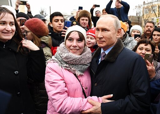 Russian President Vladimir Putin, center, right, poses for a picture with people in Ivanovo, 254 kilometers (158 miles) northeast of Moscow, Russia, Friday, March 6, 2020. Russian President Vladimir Putin said Friday he doesn't want to scrap presidential term limits or resort to other suggested ways of extending his rule, but otherwise he kept mum about his plans. (Alexei Nikolsky, Sputnik, Kremlin Pool Photo via AP)