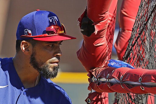 Texas Rangers' Robinson Chirinos watches batting practice during spring training baseball practice Friday, Feb. 14, 2020, in Surprise, Ariz. (AP Photo/Charlie Riedel)