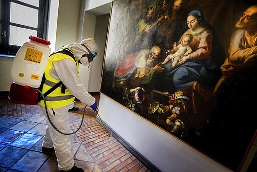 A worker sprays disinfectant as sanitization operations against Coronavirus are carried out in the museum hosted by the Maschio Angioino medieval castle, in Naples, Italy, Tuesday, March 10, 2020. (Alessandro Pone/LaPresse via AP)