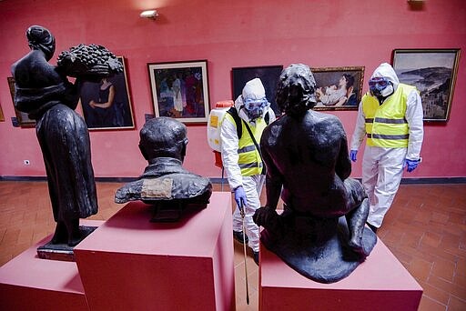 A worker sprays disinfectant as sanitization operations against Coronavirus are carried out in the museum hosted by the Maschio Angioino medieval castle, in Naples, Italy, Tuesday, March 10, 2020. (Alessandro Pone/LaPresse via AP)