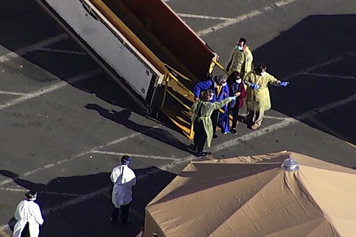 This photo taken from pool video provided by KGO-TV, shows passengers leaving the Grand Princess cruise ship at the Port of Oakland, Tuesday, March 10, 2020, in Oakland, Calif.   (KGO-TV via AP, Pool)