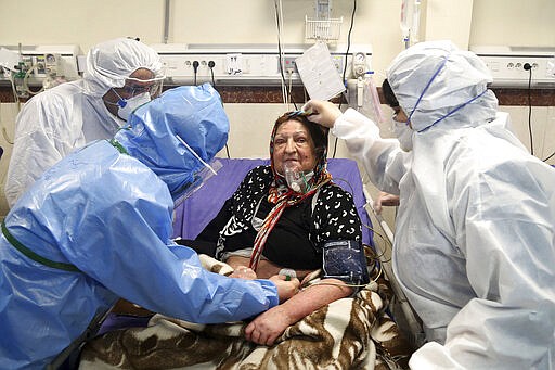 Medics treat a patient infected with the new coronavirus, at a hospital in Tehran, Iran, Sunday, March 8, 2020. With the approaching Persian New Year, known as Nowruz, officials kept up pressure on people not to travel and to stay home. Health Ministry spokesman Kianoush Jahanpour, who gave Iran's new casualty figures Sunday, reiterated that people should not even attend funerals. (AP Photo/Mohammad Ghadamali)