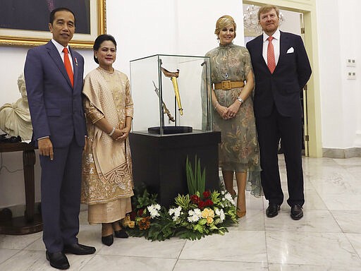 King Willem-Alexander, right, and Queen Maxima, second right, of the Netherlands with Indonesian President Joko Widodo and his wife Iriana pose in front of Prince Diponegoro keris, or dagger, that has just been returned by the Dutch government at the presidential palace in Bogor, West Java , Indonesia, Tuesday, March 10, 2020. (AP Photo/Achmad Ibrahim, Pool)