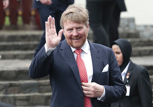 King Willem-Alexander of the Netherlands waves at reporters during a visit at a Dutch war cemetery in Jakarta, Indonesia, Tuesday, March 10, 2020. King Willem-Alexander and his wife Queen Maxima are currently on on a five-day visit in the country. (AP Photo/Dita Alangkara)