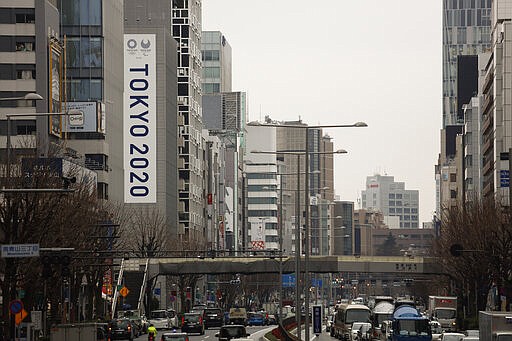 FILE - In this March 4, 2020, file photo, a large Tokyo 2020 Olympic banner hangs on the facade of a building in Tokyo. The tentacles of cancelling the Tokyo Olympics &#151; or postponing or staging it in empty venues &#151; would reach into every corner of the globe, much like the spreading virus that now imperils the opening ceremony on July 24. (AP Photo/Jae C. Hong, File)