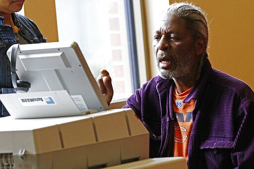 Bernell Jeuitt uses a special ballot reading machine for visually or hearing impaired or handicapped voters in a Jackson, Miss., precinct, Tuesday, March 10, 2020. Mississippi is one of several states holding party primaries today. (AP Photo/Rogelio V. Solis)