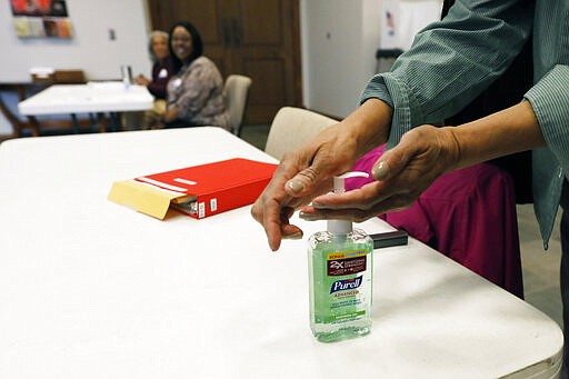 A voter takes advantage of the hand sanitizer to &quot;clean up&quot; after voting in the presidential party primary in Ridgeland, Miss., Tuesday, March 10, 2020. Polling locations are providing hand sanitizers for voters to use as a cautionary measure in light of the coronavirus health concern nationwide. (AP Photo/Rogelio V. Solis)