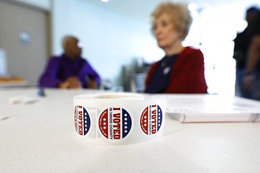 A roll of &quot;I Voted&quot; stickers rests next to ballots as poll workers wait for voters at a Jackson, Miss., precinct, Tuesday, March 10, 2020. Mississippi is one of several states holding presidential party primaries today. (AP Photo/Rogelio V. Solis)