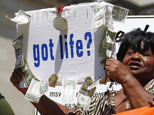 In this Sept. 15, 2010, file photograph, civil rights Democratic activist Dorothy &quot;Dot&quot; Benford of Jackson, waves a sign during a rally at the Capitol in Jackson, Miss. Benford faces one opponent, Katelyn Lee in the party primary. (AP Photo/Rogelio V. Solis, File)