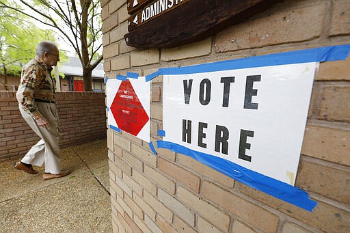 A voter walks into a Jackson, Miss., precinct, Tuesday, March 10, 2020. Mississippi is one of several states holding presidential party primaries today. (AP Photo/Rogelio V. Solis)