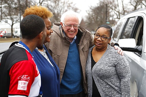 Democratic presidential candidate Sen. Bernie Sanders, I-Vt., visits custodian Davonta Bynes, from left, principal DaRhonda Evans-Stewart and social worker Kim Little outside a polling location at Warren E. Bow Elementary School in Detroit, Tuesday, March 10, 2020. (AP Photo/Paul Sancya)