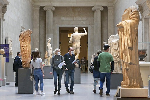 Two visitors wear masks as they walk through the Metropolitan Museum of Art in New York, Tuesday, March 10, 2020.  New York continued grappling  with the new coronavirus, as case numbers, school closings and other consequences grew.  (AP Photo/Seth Wenig)