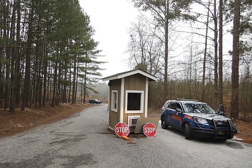 A Georgia State trooper guards an area of Hard Labor Creek State Park Wednesday, March 11, 2020, in Rutledge, Ga. The state is using the park to locate emergency mobile units to quarantine people who may have been exposed to the coronavirus. Currently, one person who tested positive for the virus is being isolated at the park, according to a statement from Gov. Brian Kemp.  (AP Photo/John Bazemore)