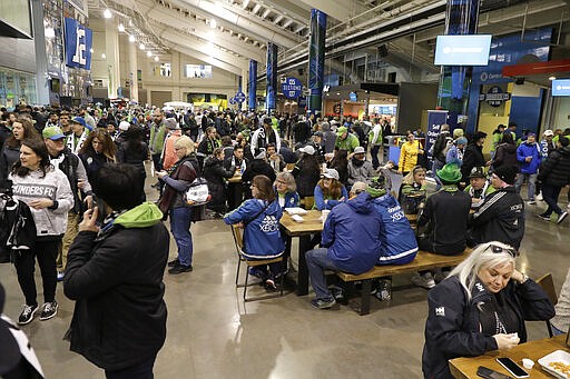 People crowd a concourse area of CenturyLink Field prior to an MLS soccer match between the Seattle Sounders and the Chicago Fire, Sunday, March 1, 2020, in Seattle. . (AP Photo/Ted S. Warren)