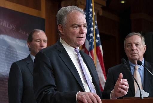 Sen. Tim Kaine, D-Va., center, joined at by Sen. Tom Udall, D-N.M., left, and Sen. Dick Durbin, D-Ill., speaks to reporters after the Senate voted to approve a bipartisan measure limiting President Donald Trump's authority to launch military operations against Iran, at the Capitol in Washington, Thursday, Feb. 13, 2020. (AP Photo/J. Scott Applewhite)