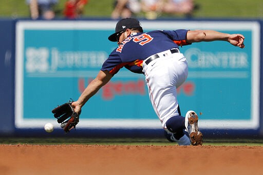 Houston Astros shortstop Jack Mayfield dives for a ground ball single by New York Mets' Michael Conforto during the third inning of a spring training baseball game Saturday, Feb. 29, 2020, in West Palm Beach, Fla. (AP Photo/Jeff Roberson)