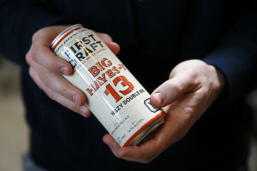 In this March 9, 2020, photo, Philadelphia Flyers' Kevin Hayes holds a can of Big Hayes-y IPA, a beer named in his honor, at Yards Brewing Company, in Philadelphia. (AP Photo/Matt Slocum)