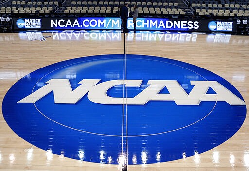 FILE - In this March 18, 2015, file photo, the NCAA logo is displayed at center court as work continues at The Consol Energy Center in Pittsburgh, for the NCAA college basketball tournament. NCAA President Mark Emmert says NCAA Division I basketball tournament games will be played without fans in the arenas because of concerns about the spread of coronavirus. (AP Photo/Keith Srakocic, File)