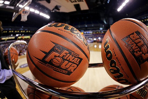 FILE - In this April 3, 2015, file photo, basketballs sit in a rack during Michigan State practice at the Final Four of the NCAA college basketball tournament in Indianapolis. NCAA President Mark Emmert says NCAA Division I basketball tournament games will be played without fans in the arenas because of concerns about the spread of coronavirus. (AP Photo/David J. Phillip, File)