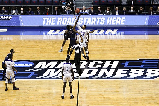 FILE - In this March 19, 2019, file photo, Fairleigh Dickinson's Kaleb Bishop (12) and Prairie View A&amp;M's Iwin Ellis (13) leap for the opening tip-off in the first half of a First Four game of the NCAA college basketball tournament in Dayton, Ohio. NCAA President Mark Emmert says NCAA Division I basketball tournament games will be played without fans in the arenas because of concerns about the spread of coronavirus. (AP Photo/John Minchillo, File)