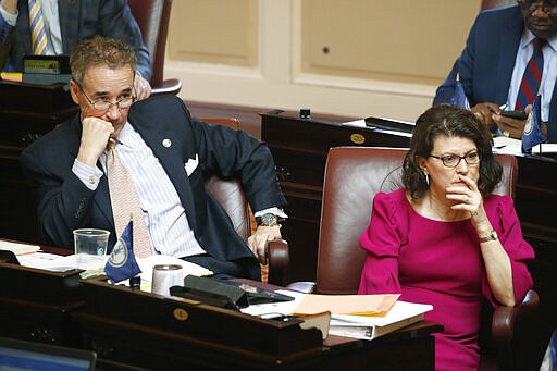 In this Wednesday, March 4, 2020 photo, State Sen. Joe Morrissey, D-Richmond, left, and Sen. Barbara Favola, D-Arlington, listen to debate on the floor during the Senate session at the Capitol in Richmond, Va. Morrissey, who calls himself &quot;Fighting Joe,&quot; has pushed his way back into the political fold. (AP Photo/Steve Helber)