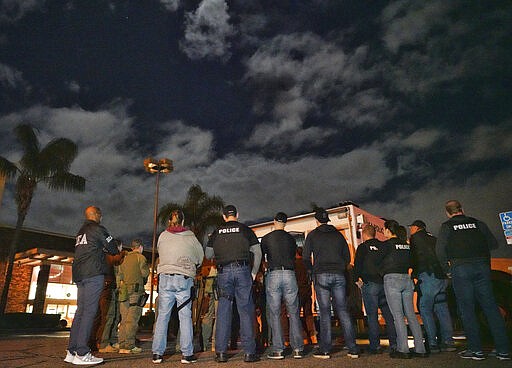 DEA agents are briefed in a parking lot prior to an arrest of a suspected drug trafficker on Wednesday, March 11, 2020 in Diamond Bar, Calif. In early-morning raids Wednesday, federal agents fanned out across the U.S., culminating a six-month investigation with the primary goal of dismantling the upper echelon of the Jalisco New Generation Cartel, known as CJNG. (AP Photo/Richard Vogel)