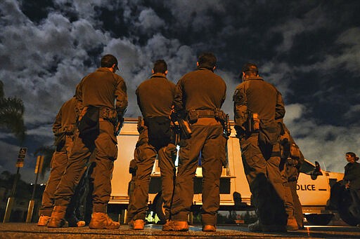 A DEA agents are briefed in a parking lot prior to an arrest of a suspected drug trafficker on Wednesday, March 11, 2020 in Diamond Bar, Calif. In early-morning raids Wednesday, federal agents fanned out across the U.S., culminating a six-month investigation with the primary goal of dismantling the upper echelon of the Jalisco New Generation Cartel, known as CJNG. (AP Photo/Richard Vogel)