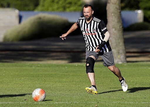 In this Wednesday, Feb. 26, 2020, photo, Al Noor mosque shooting survivor Temel Atacocugu chases the ball during a social game of soccer in Christchurch, New Zealand. When the gunman walked into the mosque, Atacocugu was kneeling for Friday prayers. He looked up into the man's face, thinking he was a police officer because of his paramilitary outfit. Time slowed. Temel saw a puff of smoke come from the raised gun, felt a bullet smash into his teeth, and thought: &quot;Oh, my God, I'm dying.&quot; (AP Photo/Mark Baker)