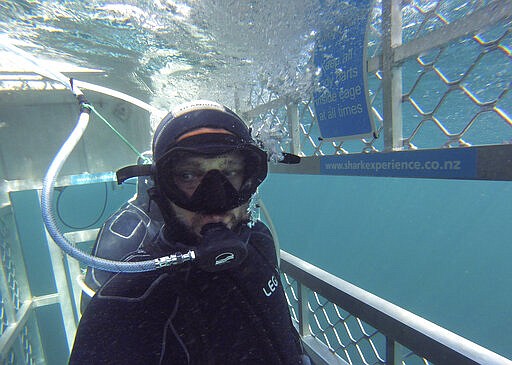 In this Jan 14, 2020, photo, Al Noor mosque shooting survivor waits in a shark cage to see great white sharks off the coast of Bluff in southern New Zealand. When the gunman walked into the mosque, Atacocugu was kneeling for Friday prayers. He looked up into the man's face, thinking he was a police officer because of his paramilitary outfit. Time slowed. Temel saw a puff of smoke come from the raised gun, felt a bullet smash into his teeth, and thought: &quot;Oh, my God, I'm dying.&quot;  (Temel Atacocugu via AP)