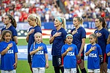 American women hide US Soccer logo during anthem in protest