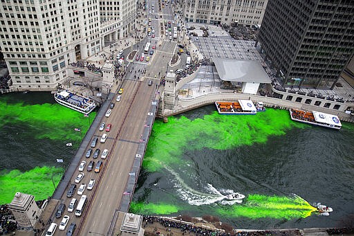 FILE - In this March 17, 2018 file photo, boats move through the water as the Chicago River is dyed green for St. Patrick's Day in Chicago. Chicago on Wednesday, March 11, 2020 joined the growing ranks of cities across the United States to cancel its Saturday St. Patrick's Day Parade amid concerns about the coronavirus. The city will not be dyeing the river green either. For most people, the new coronavirus causes only mild or moderate symptoms, such as fever and cough. For some, especially older adults and people with existing health problems, it can cause more severe illness, including pneumonia. (Erin Hooley/Chicago Tribune via AP File)