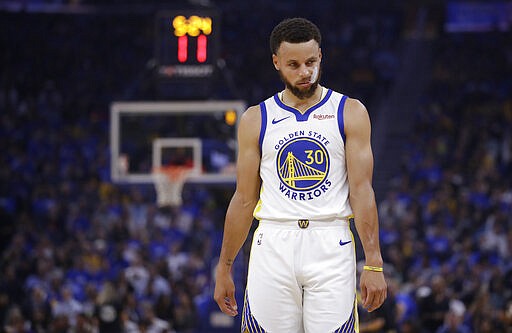 FILE - In this Oct. 24, 2019, file photo, Golden State Warriors' Stephen Curry walks on the court during the first half of an NBA basketball game against the Los Angeles Clippers in San Francisco. The Warriors will play the Brooklyn Nets at home Thursday night, March 12, 2020, in the first NBA game without fans since the outbreak of the coronavirus. (AP Photo/Ben Margot, File)