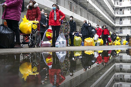 In this Tuesday, March 10, 2020, photo released by Xinhua News Agency, people recovered from coronavirus prepare to leave the rehabilitation center after a 14-day quarantine for medical observation in Wuhan in central China's Hubei province. The province at the center of China's virus outbreak is allowing factories and some other businesses to reopen in a new sign Beijing believes the disease that devastated its economy is being brought under control. (Xiong Qi/Xinhua via AP)