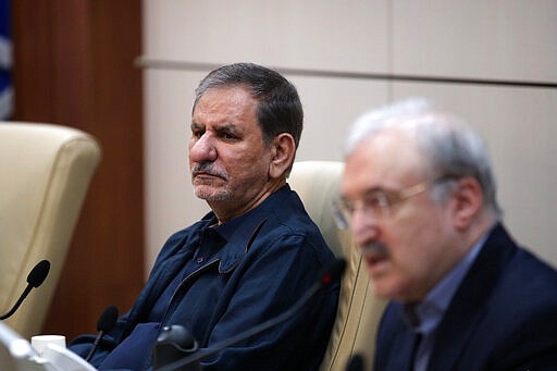 In this Feb. 28, 2020 photo, released by official website of the Office of the Iranian Vice-President, Senior Vice-President Eshaq Jahangiri, left, listens as Minister of Health and Medical Education Saeed Namaki speaks at the Headquarters of Prevention and Combating the Coronavirus, in Tehran, Iran. Jahangiri and two other Cabinet members have contracted the new coronavirus, semiofficial Fars News Agency reported Wednesday, March 11, 2020. The vast majority of people recover from the new virus. (Office of the Iranian Vice President via AP)