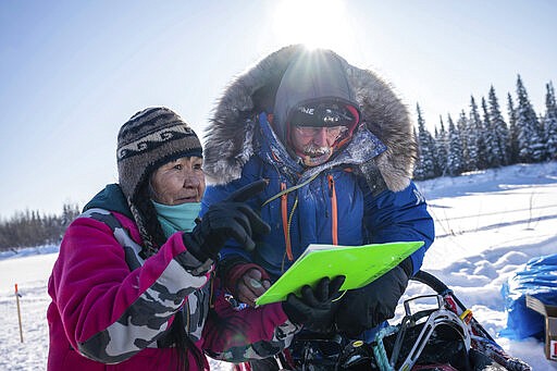 Marty Runkle checks in musher Mitch Seavey at the Nikolai, Alaska, checkpoint  Tuesday, March 10, 2020, during the Iditarod Trail Sled Dog Race. (Loren Holmes/Anchorage Daily News via AP)