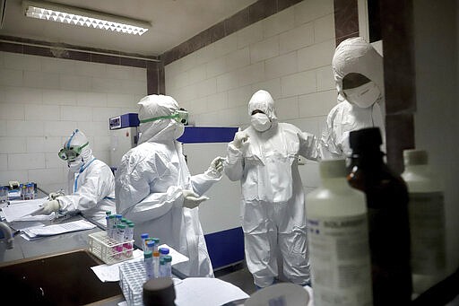 In this Tuesday, March, 10, 2020 photo, paramedics work in a laboratory that tests samples taken from patients suspected of being infected with the new coronavirus, in the southwestern city of Ahvaz, Iran. For most people, the new coronavirus causes only mild or moderate symptoms, such as fever and cough. For some, especially older adults and people with existing health problems, it can cause more severe illness, including pneumonia. (Amin Nazari/ISNA via AP)