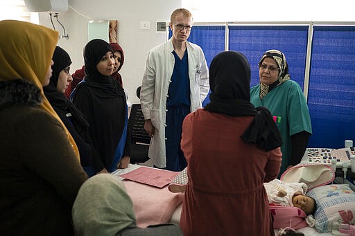 Dr. Vitaly Dedovich, of the Novick Cardiac Alliance medical team, center, and Dr. Hanifa Alrabti, right, talk to a patient's mother at the Tajoura National Heart Center in Tripoli, Libya, on Feb. 24, 2020. Novick&#146;s group not only drops in a few times a year, but also trains Libyan doctors and nurses to build up the country&#146;s critical health care system. (AP Photo/Felipe Dana)