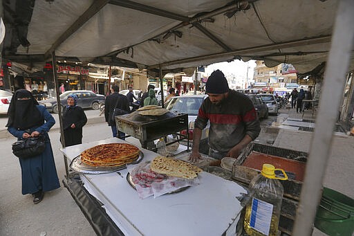 Man bakes bread in the city of Idlib, Syria, Monday, March 9, 2020 during the truce, brokered by Turkey and Russia, which halted a terrifying three-month air and ground campaign that killed hundreds and sent 1 million people fleeing toward the Turkish border. (AP Photo/Ghaith Alsayed)