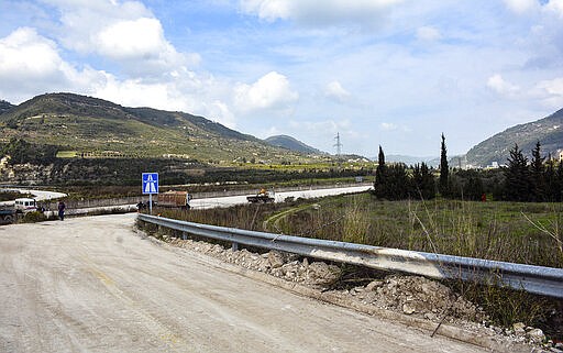 This Tuesday, March. 10, 2020 photo, released by the Syrian official news agency SANA, shows workers removing barriers from the road that links Syria's coastal region with the northern city of Aleppo, in Latakia province, Syria. The reopening of the M4 highway that has been closed since 2012 is part of a deal reached earlier this month between Turkey and Russia that stopped a Russian-backed government offensive on the northwestern province of Idlib, the last rebel stronghold in the country. (SANA via AP)