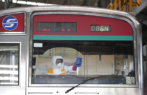 A worker wearing protective gear disinfects as a precaution against the new coronavirus at a subway car depot in Seoul, South Korea, Wednesday, March 11, 2020. For most people, the new coronavirus causes only mild or moderate symptoms, such as fever and cough. For some, especially older adults and people with existing health problems, it can cause more severe illness, including pneumonia. (AP Photo/Lee Jin-man)