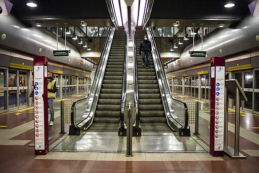 A man wearing a mask descends an escalator at a subway station in Milan, Italy, Wednesday, March 11, 2020. In Italy the government extended a coronavirus containment order previously limited to the country&#146;s north to the rest of the country beginning Tuesday, with soldiers and police enforcing bans. For most people, the new coronavirus causes only mild or moderate symptoms, such as fever and cough. For some, especially older adults and people with existing health problems, it can cause more severe illness, including pneumonia. (Claudio Furlan/LaPresse via AP)