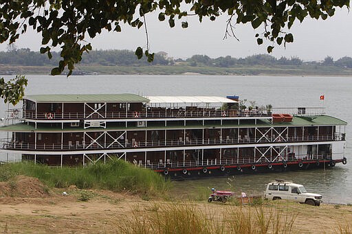 Officials arrive to take samples from some passengers near a cruise boat docked along the Mekong River bank in Kampong Cham, Cambodia, Wednesday, March 11, 2020. Passengers and crew of the cruise boat that sailed on the Mekong River from Vietnam to Cambodia have been asked to stay onboard by Cambodian health authorities after a British passenger was confirmed to have been infected with COVID-19. (AP Photo/Heng Sinith)