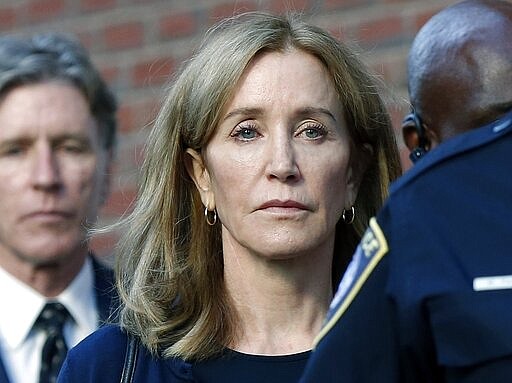 FILE &#151; In this Friday, Sept. 13, 2019, file photo, Felicity Huffman leaves federal court in Boston with her brother Moore Huffman Jr., background left, after she was sentenced in a nationwide college admissions bribery scandal. Twenty one parents, including Huffman, have admitted to paying bribes to have someone cheat on their children's entrance exams or pretend their kids were star athletes for sports they didn't play. (AP Photo/Michael Dwyer, File)