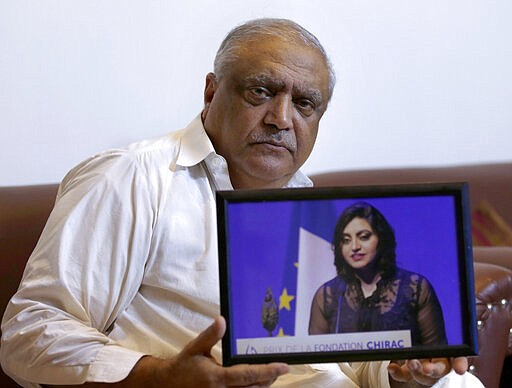 FILE - In this Oct. 17, 2019, file photo, Professor Mohammad Ismail, father of Pakistani human rights activist Gulalai Ismail, holds a photo of his daughter in Islamabad, Pakistan. Gulalai Ismail was charged under the anti-terrorism act after she criticized army actions in the border regions. In Pakistan, being a dissident or even raising a critical voice is dangerous business. Rights groups say that despite the election in 2018 of a civilian government, the army still rules from behind with an iron fist. (AP Photo/Anjum Naveed, File)