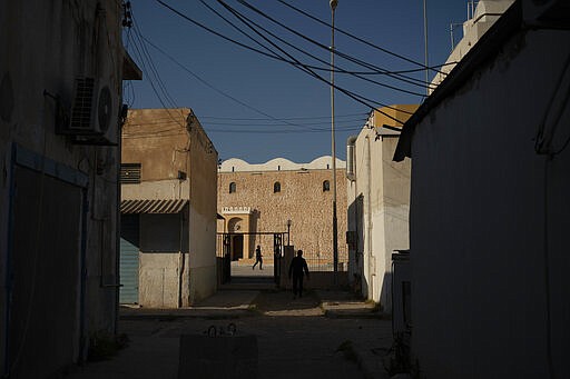 People walk outside a mosque in Tripoli, Libya, on Feb. 27, 2020. Eastern-based opposition forces attacked Tripoli last spring to wrest it from control of the weak U.N.-backed government. The fierce round of fighting has killed hundreds of civilians, including at least 13 children since mid-January. (AP Photo/Felipe Dana)