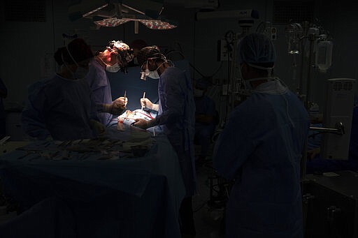 Dr. Vitaly Dedovich, center left, of the Novick Cardiac Alliance medical team performs open heart surgery on Yazan, 1, at the Tajoura National Heart Center in Tripoli, Libya, on Feb. 27, 2020. The team was the best, and perhaps last, hope for Yazan. But that meant his family had to travel to the most dangerous place in the war-ravaged country &#151; the capital Tripoli, where the Tajoura National Heart Center is located. (AP Photo/Felipe Dana)