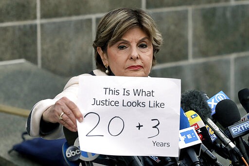 Attorney Gloria Allred holds a sign as she meets the press after Harvey Weinstein's sentencing, in New York, Wednesday, March 11, 2020. Weinstein was sentenced to 23 years in prison for rape and sexual assault. (AP Photo/Mark Lennihan)