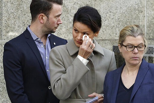 Tarale Wulff, center, wipes her eye before she speaks to the press after Harvey Weinstein's sentencing, in New York, Wednesday, March 11, 2020. Weinstein was sentenced to 23 years in prison for rape and sexual assault. During Weinstein's trial, Wulff testified that the one-time Hollywood titan raped her at his New York City apartment after luring her there in 2005 with promises of an audition for a film role.  (AP Photo/Mark Lennihan)