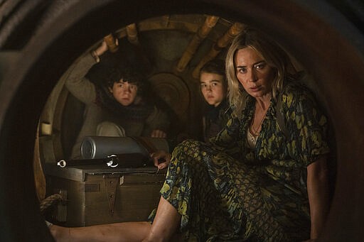 This image released by Paramount Pictures shows Noah Jupe, from left, Millicent Simmonds, and Emily Blunt in a scene from &quot;A Quiet Place Part II.&quot; The entertainment industry, a business predicated on drawing crowds in theaters, cinemas and concert venues, braced Thursday, March 12, 2020, for a potential shutdown from the coronavirus as upcoming movies were canceled, festivals scuttled and live audiences eliminated from television shows. John Krasinski, writer and director of &#147;A Quiet Place 2,&quot; announced Thursday that his film from Paramount Pictures would not open next week as planned but be postponed to as yet-announced date. (Jonny Cournoyer/Paramount Pictures via AP)