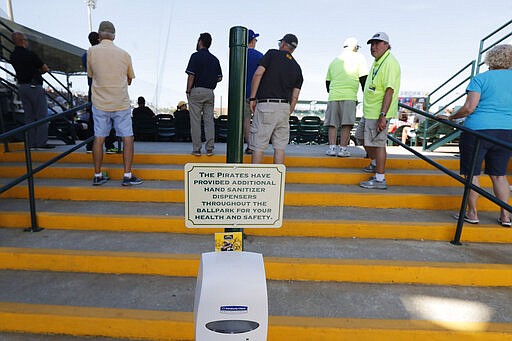 A hand sanitizer dispenser is seen during a spring training baseball game between the Pittsburgh Pirates and the Toronto Blue Jays, Thursday, March 12, 2020, in Bradenton, Fla. (AP Photo/Carlos Osorio)